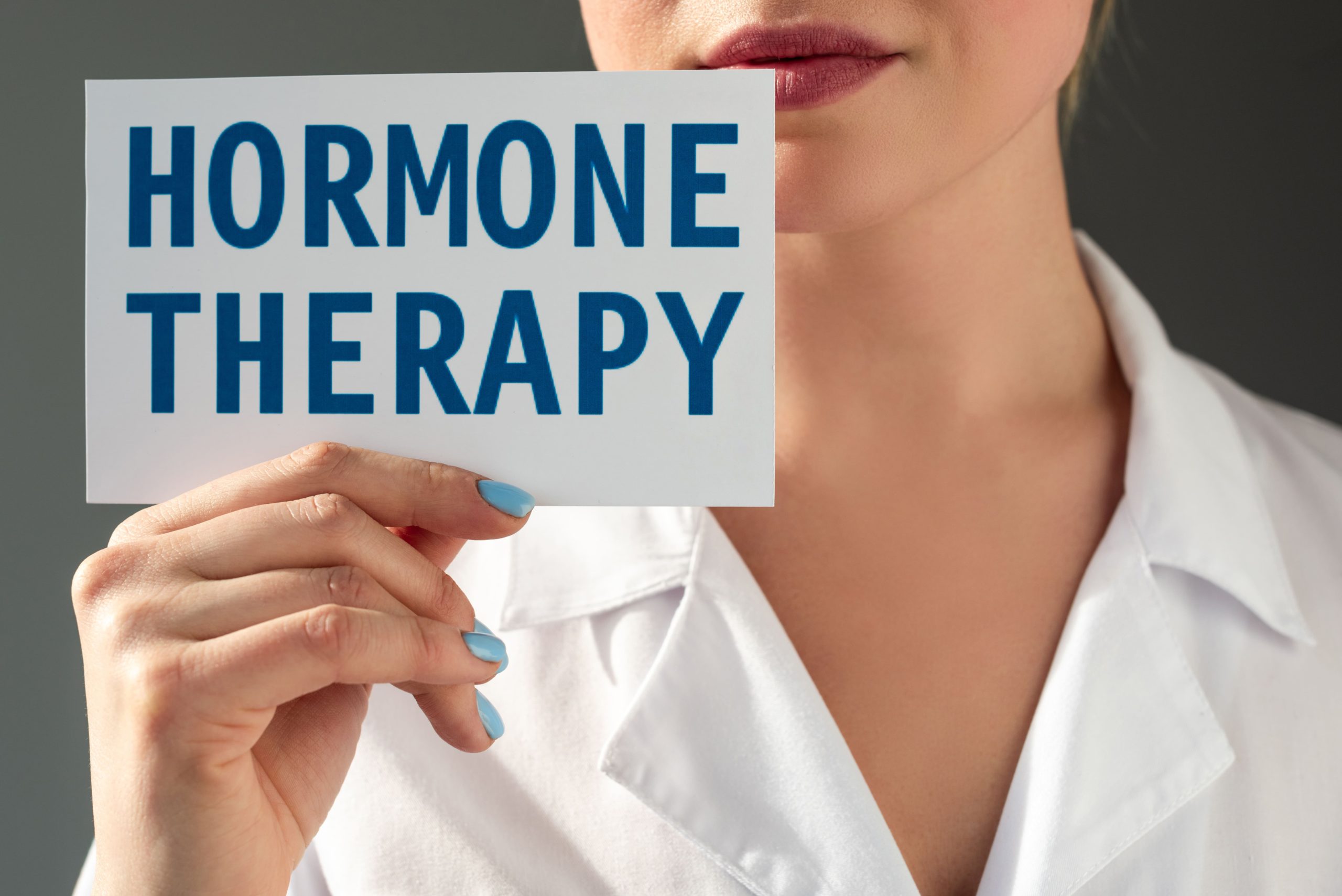 woman holding sign saying hormone therapy