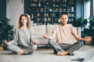 calm-couple-in-pajamas-meditating-sitting-on-lotu-