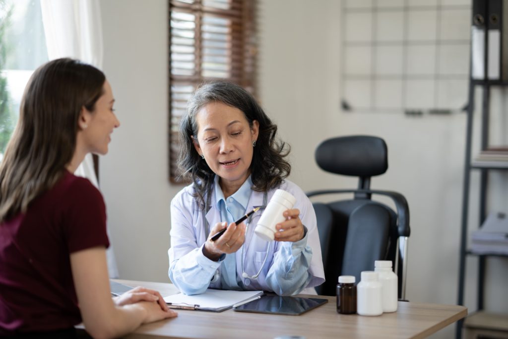 senoir-female-doctor-explaining-bottle-of-medicine