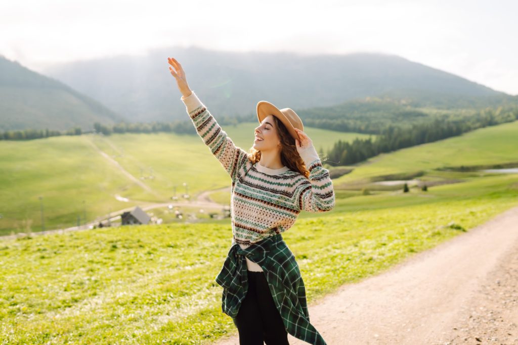 happy-female-traveler-exploring-area-in-green-