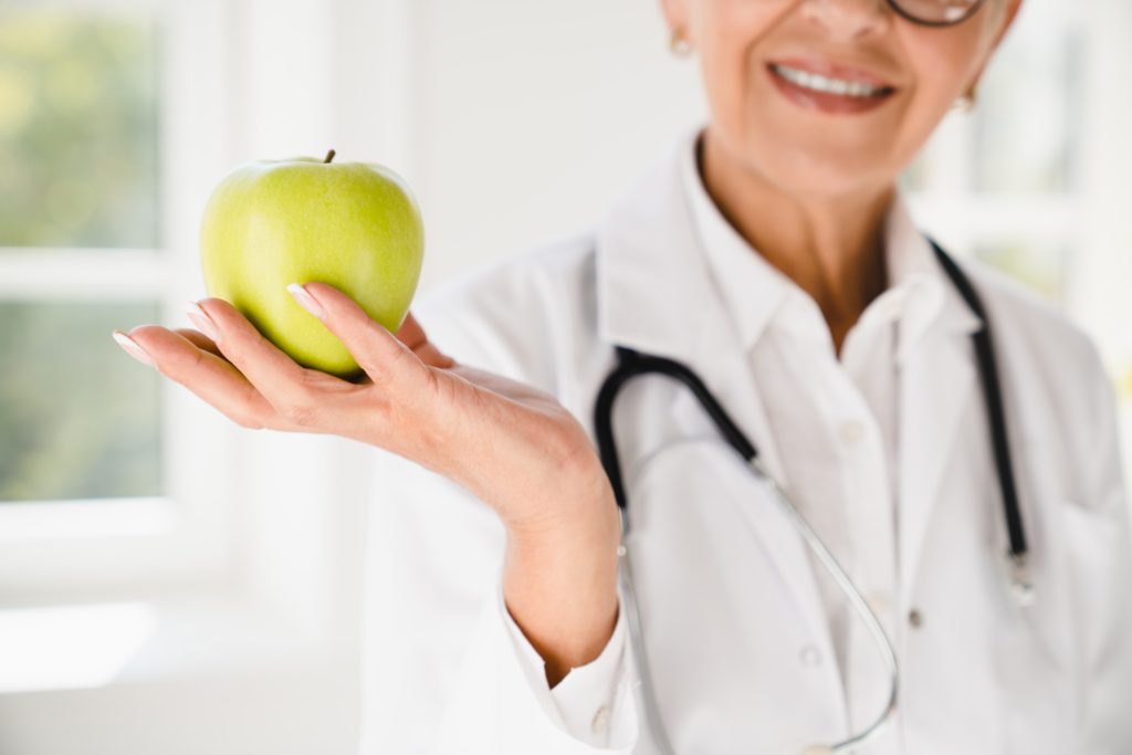 dietitian-doctor-nutritionist-showing-green-apple